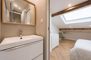 ein Badezimmer mit Waschbecken und Spiegel und einem Bett in der Unterkunft F2 très cosy (calme) coeur de ville 1min de la plage in Saint-Raphaël + 12 Fotos