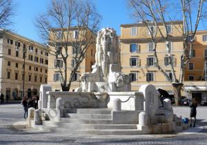 una statua in mezzo a una piazza con edifici di Appartamenti con vista Piazza Testaccio a Roma