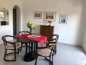stół jadalny z krzesłami i wazon kwiatów w obiekcie Apartment KoKa w mieście Ermioni