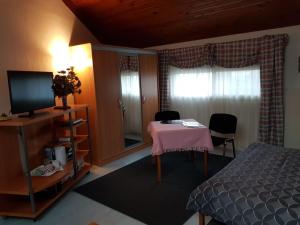 1 dormitorio con cama, mesa y TV en Villa Le Rabailly en Mérenvielle
