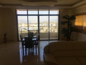 a living room with a couch and a table with chairs at Koura Nahla Apartment in An Nakhlah
