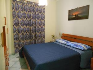 a bedroom with a blue bed and a curtain at Domus Acanfora in Pompei