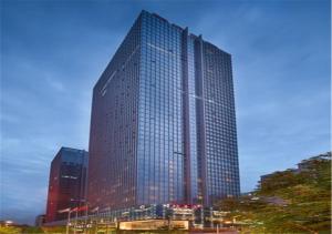 a tall building with many windows in a city at Jinan Inzone Royal Plaza Hotels in Jinan