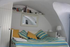 a bedroom with a bed with colorful pillows and a mirror at The Studio, Leonidio in Leonidio