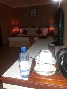 una botella de agua sentada en un mostrador junto a una mesa en Lemigo Hotel, en Kigali