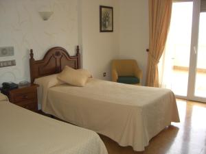 A bed or beds in a room at Hotel Heredero