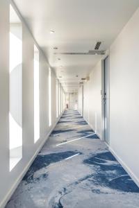 an empty corridor in an office building with a blue floor at Seeko'o Hotel Bordeaux in Bordeaux +49 photos