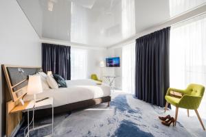 a bedroom with a bed and a desk and a chair at Seeko'o Hotel Bordeaux in Bordeaux