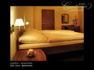 a bedroom with a bed and a table and a lamp at Parkhotel Centrum in Spišská Nová Ves