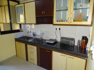 a kitchen with wooden cabinets and a counter top with a microwave at Casale Majorda in Majorda