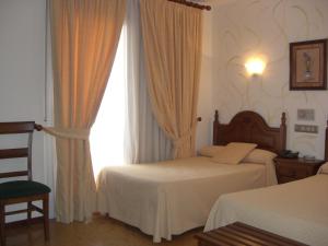 A bed or beds in a room at Hotel Heredero