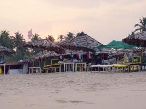 a beach with tables and chairs and straw umbrellas at Casale Majorda in Majorda