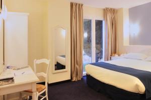 a bedroom with a bed and a desk and a mirror at Best Western Hôtel Le Sud in Manosque