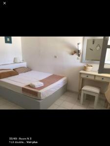 1 dormitorio con cama y escritorio con espejo en Villa Campos Yalos beach, en Ios Chora