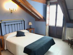 um quarto com uma cama grande e uma janela em Posada La Cabaña De Salmon em Santillana del Mar