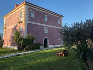 um grande edifício vermelho com um banco à frente em Villa Giulia em Lamezia Terme