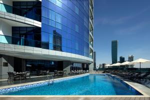 a swimming pool in front of a building at Radisson Blu Hotel, Dubai Waterfront in Dubai