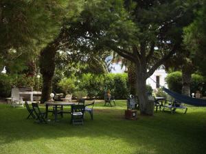 a park with picnic tables and a hammock under a tree at Finca Malyma with 2 villas and 1 apartment, beach front 10,000m2 botanic garden in Zahora