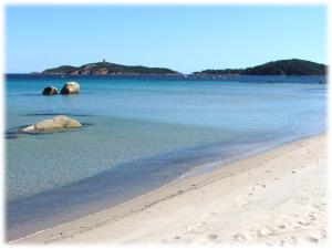 a beach with some rocks in the water at U Paesolu in Sainte-Lucie de Porto-Vecchio