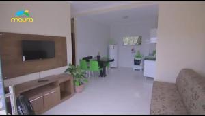 sala de estar con sofá y TV en la pared en Condomínio Maura, en Porto Seguro