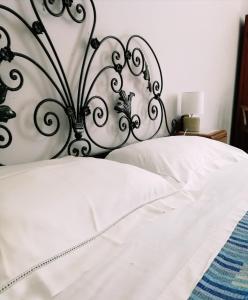 a white bed with a black and white head board at B&B Faro Bianco in Otranto