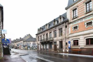 eine Stadtstraße mit Gebäuden an einem regnerischen Tag in der Unterkunft Les pieds dans l'eau,la tête dans les nuages in Luxeuil-les-Bains