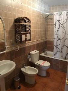 a bathroom with a toilet and a sink and a tub at Cortijo Clemente in Frigiliana