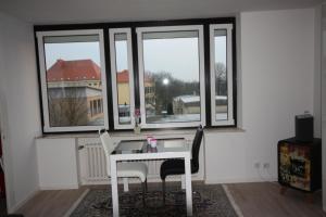 フーズムにあるFerienwohnung Wattkiekerの窓付きの客室で、白いテーブルと椅子が備わります。
