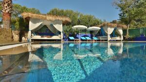 a swimming pool with chairs and umbrellas in a resort at B&B Boutique Hotel in Dalyan