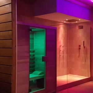 baño con ducha de cristal con iluminación morada y verde en Villa Edda Heated Pool, en Galatina