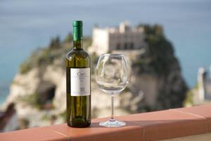 トロペアにあるLo Splendore del Borgoのグラスワインの横にワイン1本