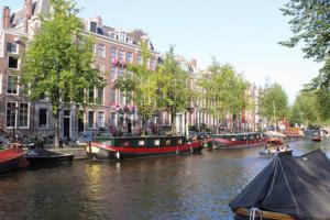 een groep boten op een rivier in een stad bij Amsterdam Appartment in the centre of Amsterdam in Amsterdam