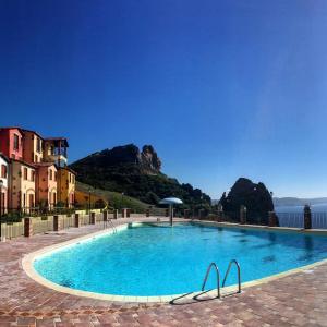 a large swimming pool with a mountain in the background at Il Veliero Tanca Piras in Nebida