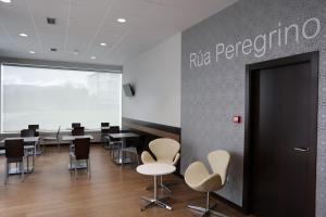 a conference room with tables and chairs and a sign that reads rico performance at Pensión Rúa Peregrino in Sarria