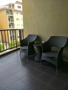 two chairs and a table on a balcony at Lala House, Gold Coast Morib Resort in Banting