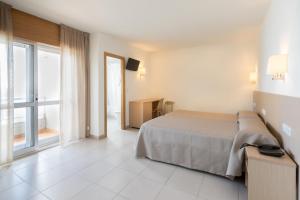 una camera da letto con un letto e una grande finestra di Hotel Duna a Portonovo
