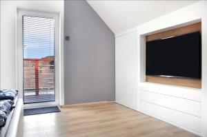 a living room with a flat screen tv on a wall at Shambala Apartman Tihany in Tihany