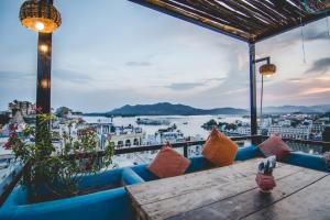 a view of a harbor from a restaurant with a wooden table at Banjara Retreat in Udaipur