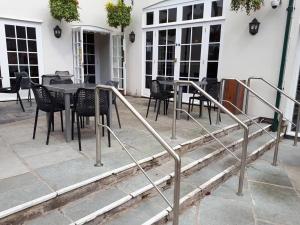 un patio con mesa y sillas frente a un edificio en The George Hotel Wetherspoon en Brecon