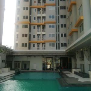 a building with a swimming pool in front of a building at Pakubuwono Terrace Apartment in Jakarta
