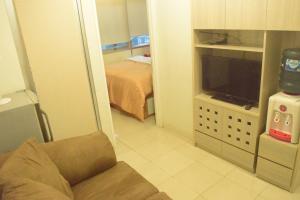 a living room with a couch and a television at Pakubuwono Terrace Apartment in Jakarta