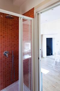 y baño con ducha de azulejos rojos. en Altana Bologna, en Bolonia