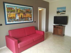 een woonkamer met een rode bank en een flatscreen-tv bij Appartamento Alessio in Bardolino