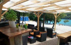 eine Terrasse mit Tisch und Stühlen unter einem Pavillon in der Unterkunft Studio Elvis in Plomin