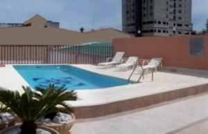 a swimming pool with a bunch of chairs and a table at Hotel Presidente in Uruguaiana