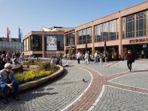 a person sitting on a bench in front of a building at City Central Promenade in Bad Homburg vor der Höhe