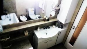 a bathroom with a sink and a toilet and a mirror at Tomis Apartament in Constanţa +23 photos