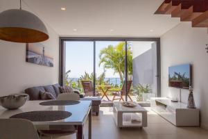 a living room with a couch and a table at Quinta Golfinho in Arco da Calheta