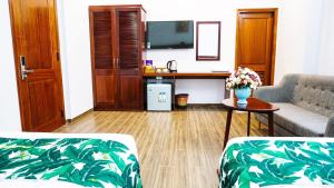 a living room with a couch and a table with flowers at Flora Quy Nhon Hotel in Quy Nhon