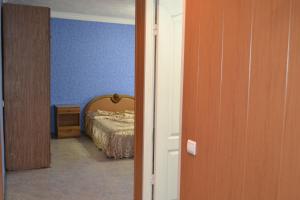 a bedroom with a bed and a blue wall at Уютная 1-квартира в центре города in Shakhty